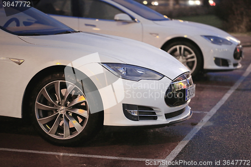 Image of Two White Tesla Model S Cars at Night