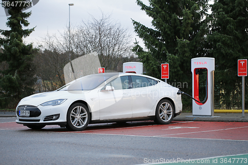 Image of White Tesla Model S being Charged at Supercharger Station