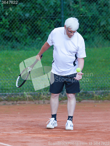 Image of Senior man playing tennis