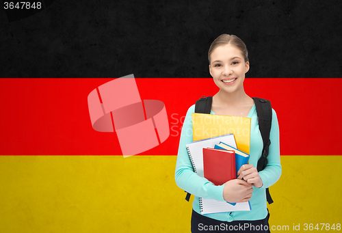 Image of happy and smiling teenage student girl with books