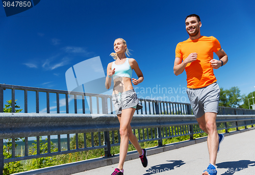 Image of smiling couple running at summer seaside