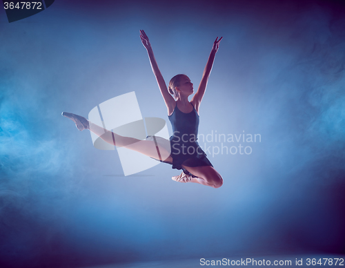 Image of The silhouette of young ballet dancer jumping on a blue background.