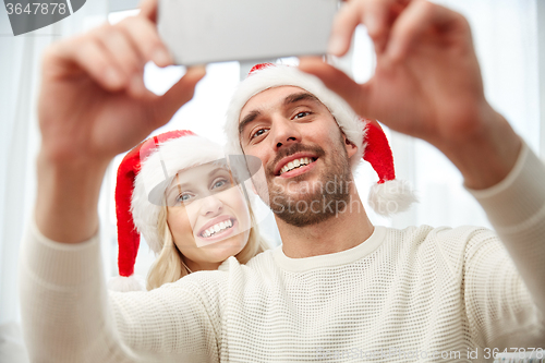 Image of couple taking selfie with smartphone at christmas