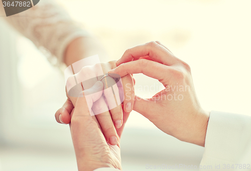 Image of close up of lesbian couple hands with wedding ring