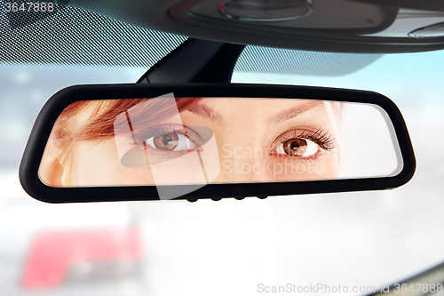 Image of woman looks to rear-view mirror