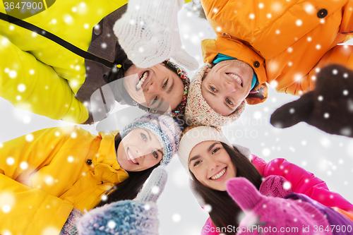 Image of happy friends in winter clothes outdoors