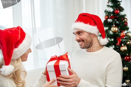 Image of happy couple at home with christmas gift box