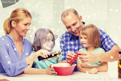 Image of happy family with two kids making salad at home