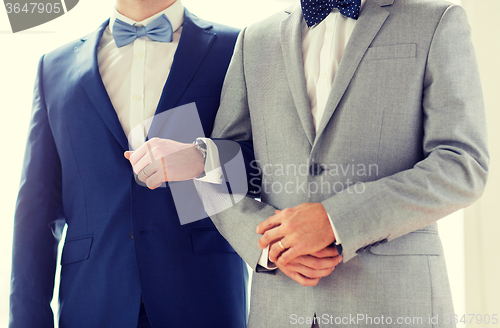 Image of close up of happy male gay couple holding hands