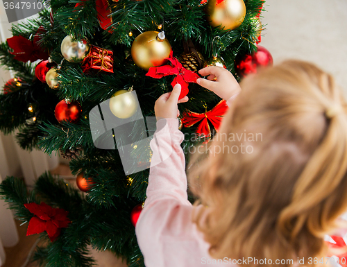 Image of close up of child decorating christmas tree