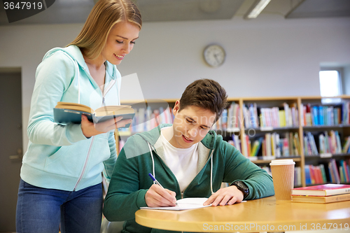 Image of happy students preparing to exams in library