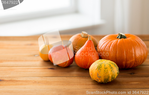 Image of close up of pumpkins on wooden table at home