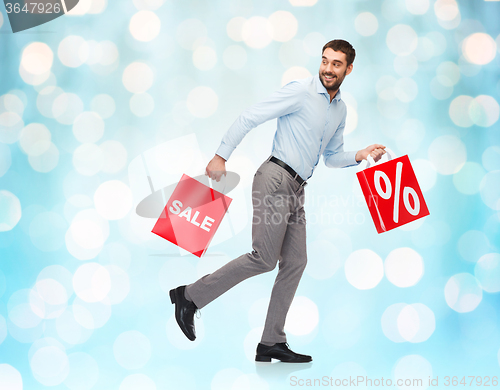 Image of smiling man with red shopping bag