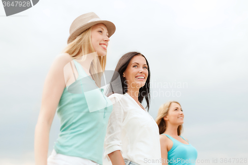 Image of group of smiling girls chilling on the beach