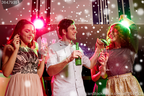 Image of smiling friends with wine glasses and beer in club