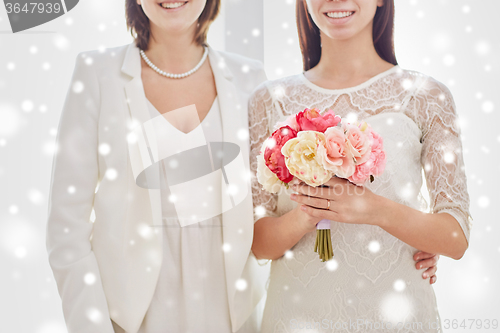 Image of close up of happy lesbian couple with flowers