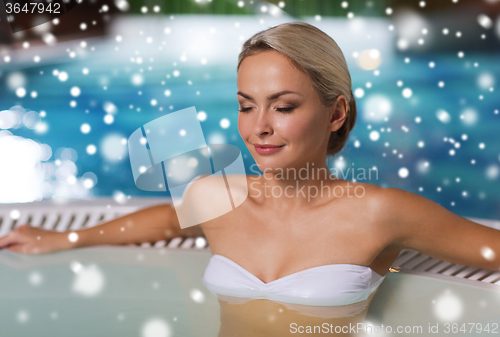 Image of happy woman sitting in jacuzzi at poolside