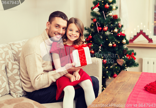 Image of smiling father and daughter holding gift box