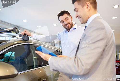 Image of happy man with car dealer in auto show or salon