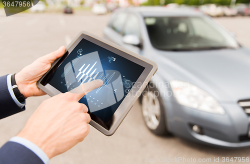 Image of close up of man with tablet pc diagnoses car