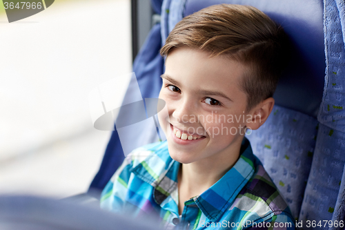 Image of happy boy sitting in travel bus or train