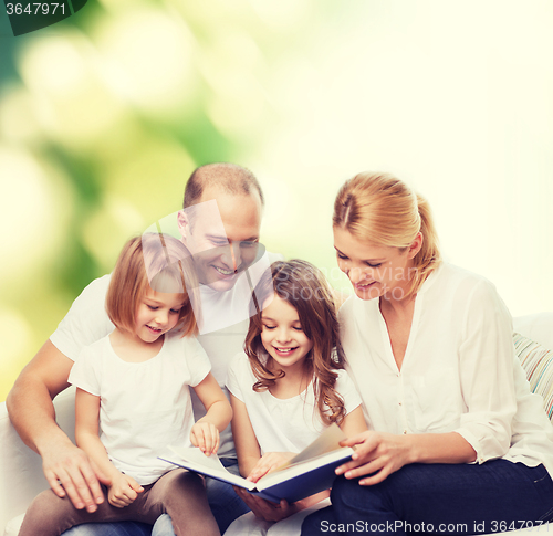 Image of happy family with book at home