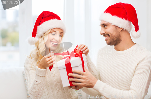 Image of happy couple at home with christmas gift box