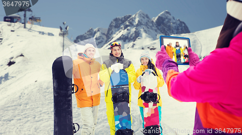 Image of happy friends with snowboards and tablet pc