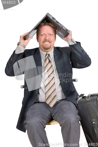 Image of Traveling businessman hiding under laptop