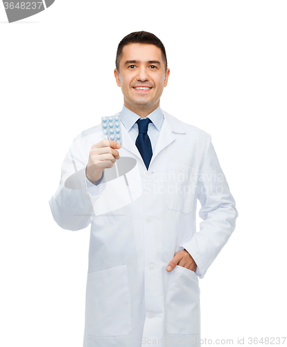 Image of smiling male doctor in white coat with tablets