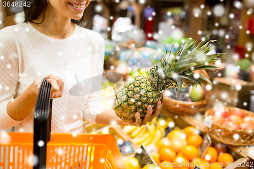Image of close up of woman with pineapple in grocery market