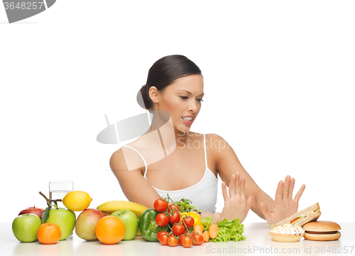 Image of woman with fruits rejecting hamburger