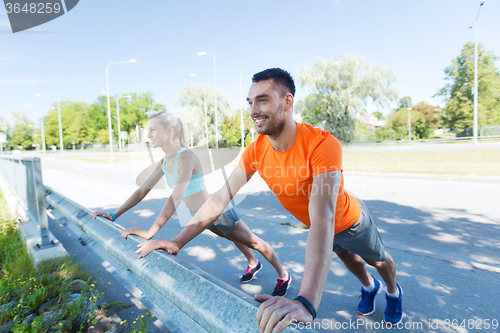 Image of close up of happy couple doing push-ups outdoors