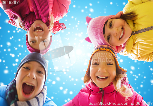 Image of happy little children faces over blue sky and snow