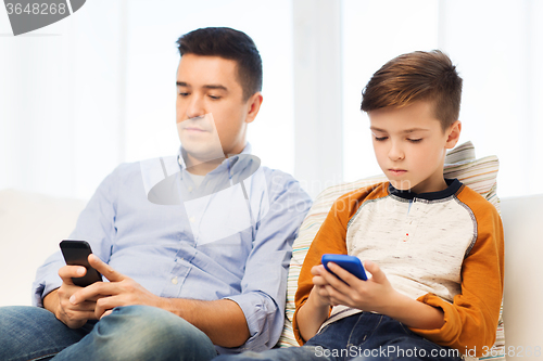 Image of father and son with smartphones at home