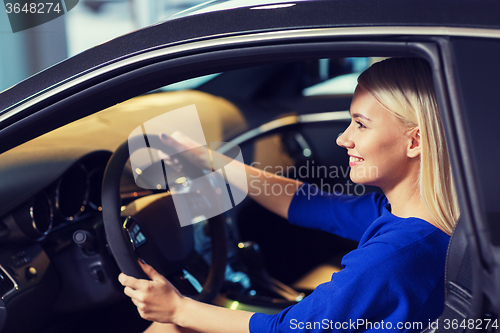 Image of happy woman inside car in auto show or salon