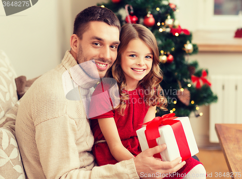 Image of smiling father and daughter holding gift box