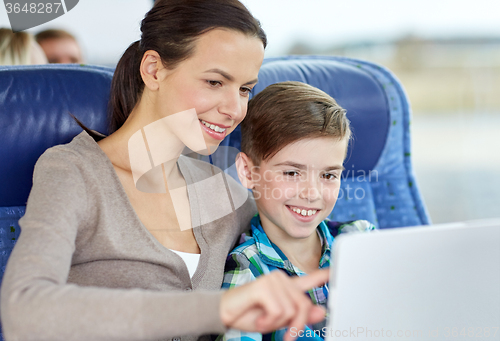 Image of happy family with tablet pc sitting in travel bus