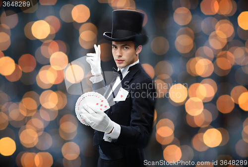 Image of magician showing trick with playing cards