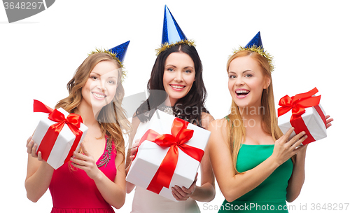 Image of three smiling women in blue hats with gift boxes