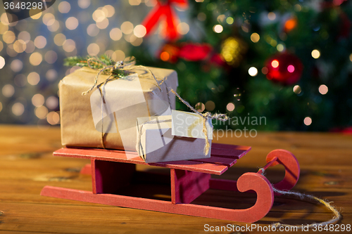 Image of close up of christmas gift boxes on wooden sleigh