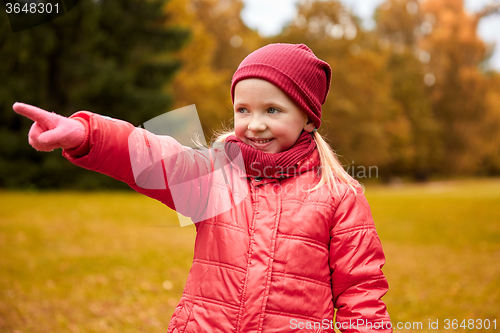 Image of happy little girl pointing finger in autumn park