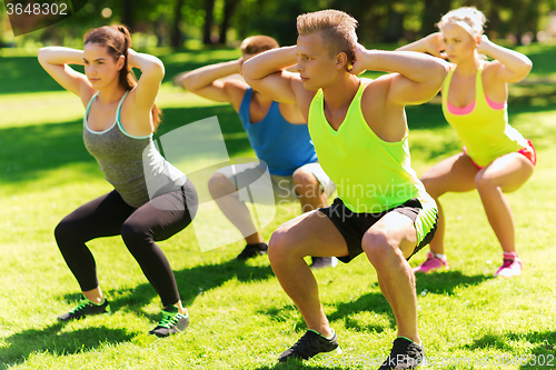 Image of group of friends or sportsmen exercising outdoors