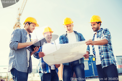 Image of group of builders with tablet pc and blueprint