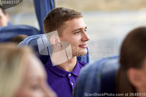 Image of happy young man sitting in travel bus