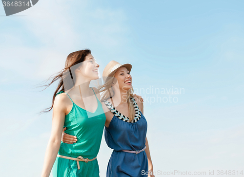 Image of smiling girls walking on the beach