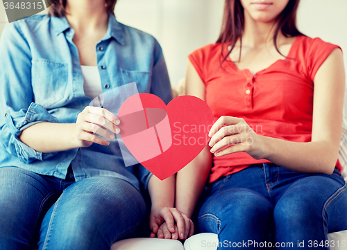 Image of close up of happy lesbian couple with red hearts