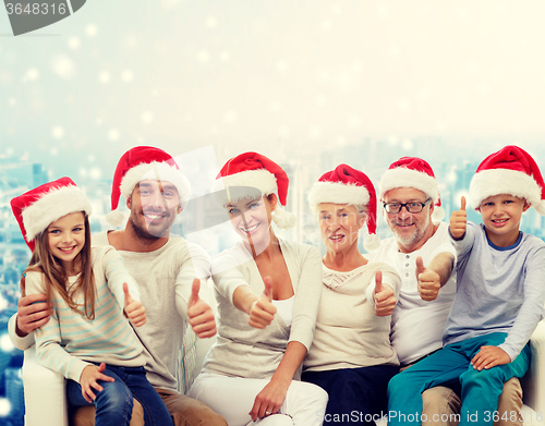 Image of happy family in santa hats showing thumbs up