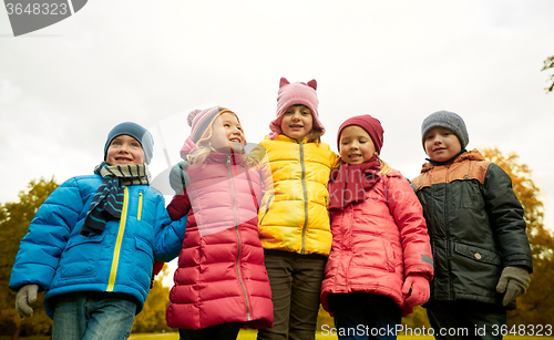 Image of group of happy children hugging in autumn park