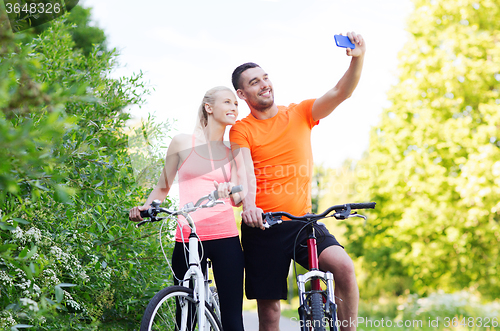 Image of couple with bicycle taking selfie by smartphone
